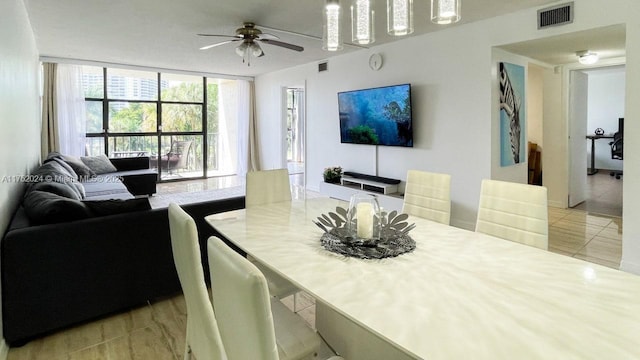 dining area with light tile patterned floors, ceiling fan, expansive windows, and visible vents