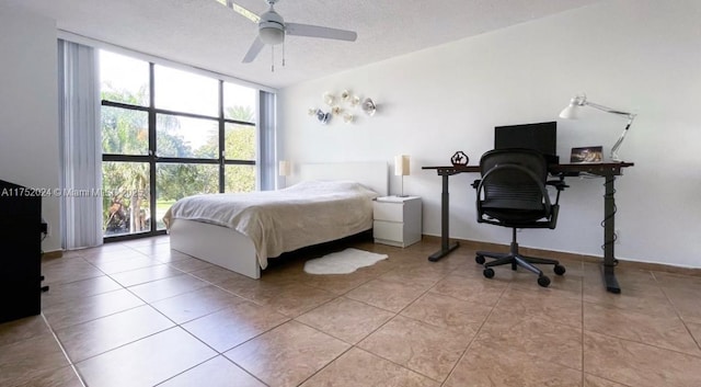 bedroom featuring light tile patterned floors, ceiling fan, a textured ceiling, a wall of windows, and baseboards