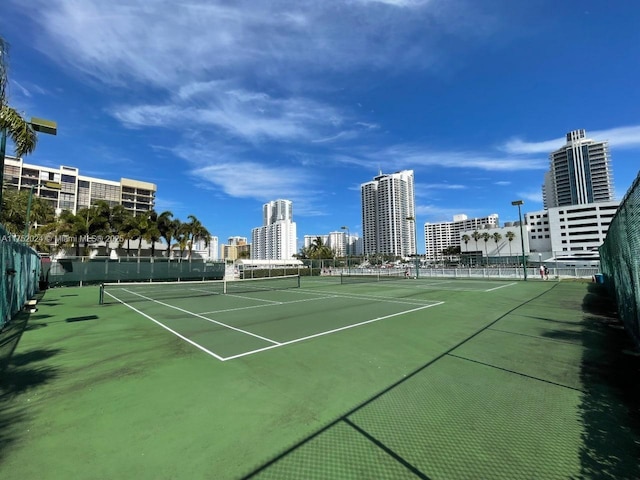 view of sport court with fence and a city view