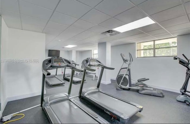 exercise room featuring visible vents, baseboards, and a drop ceiling