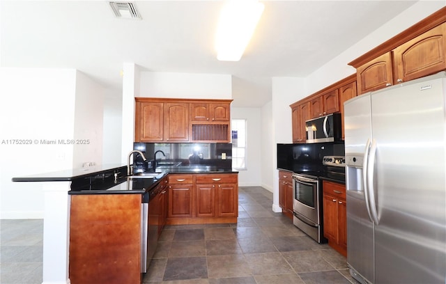 kitchen with dark countertops, visible vents, a peninsula, and appliances with stainless steel finishes