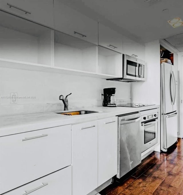 kitchen with open shelves, light countertops, appliances with stainless steel finishes, white cabinetry, and a sink