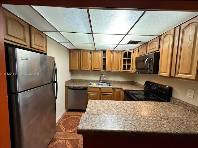 kitchen with visible vents, a drop ceiling, glass insert cabinets, black appliances, and a sink