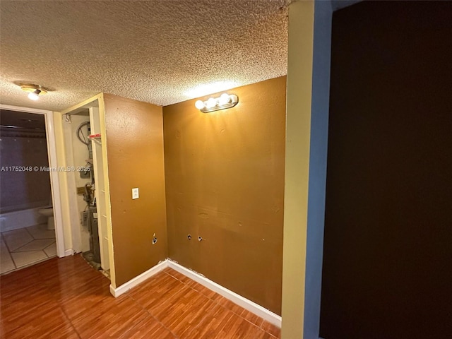 washroom featuring baseboards and a textured ceiling