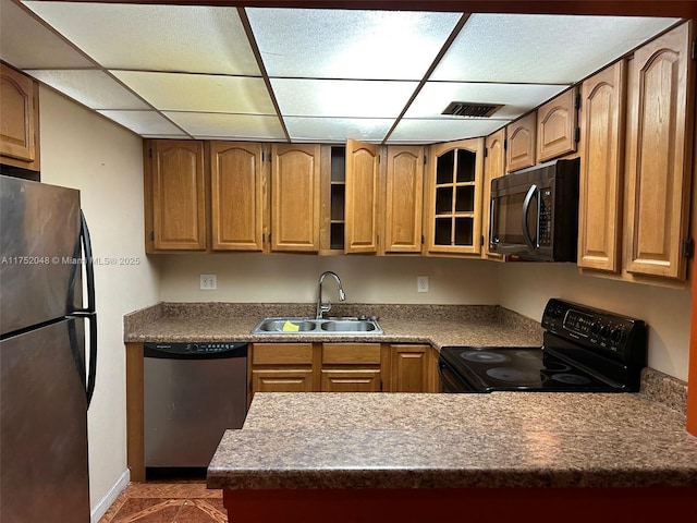 kitchen with glass insert cabinets, brown cabinetry, a sink, and black appliances