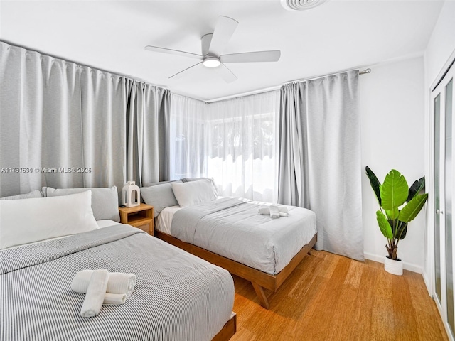 bedroom with light wood-type flooring and a ceiling fan