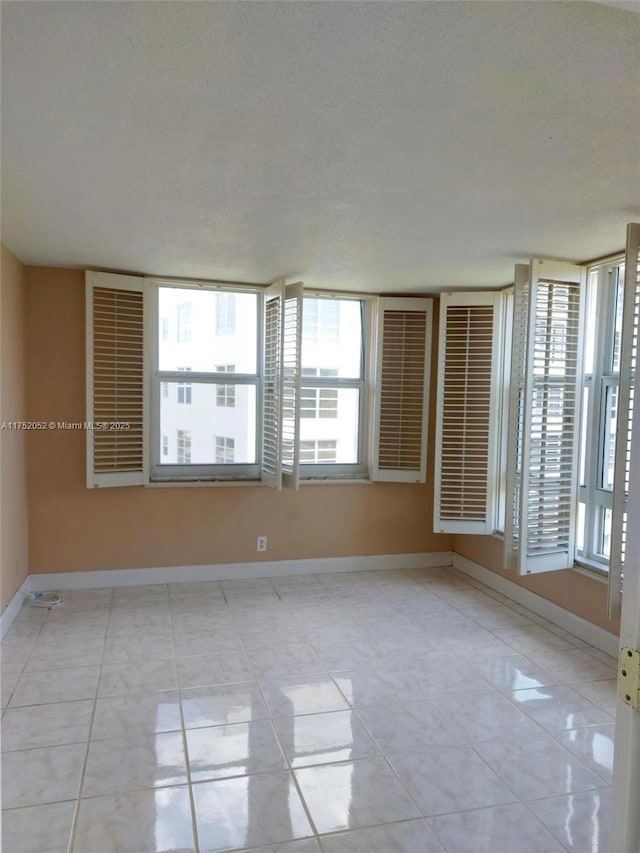 2650 S Course Dr Unit 410, Pompano Beach, FL 33069 - spare room with baseboards and a textured ceiling