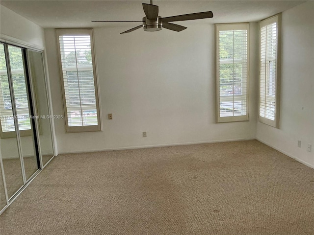 spare room featuring a ceiling fan and light colored carpet