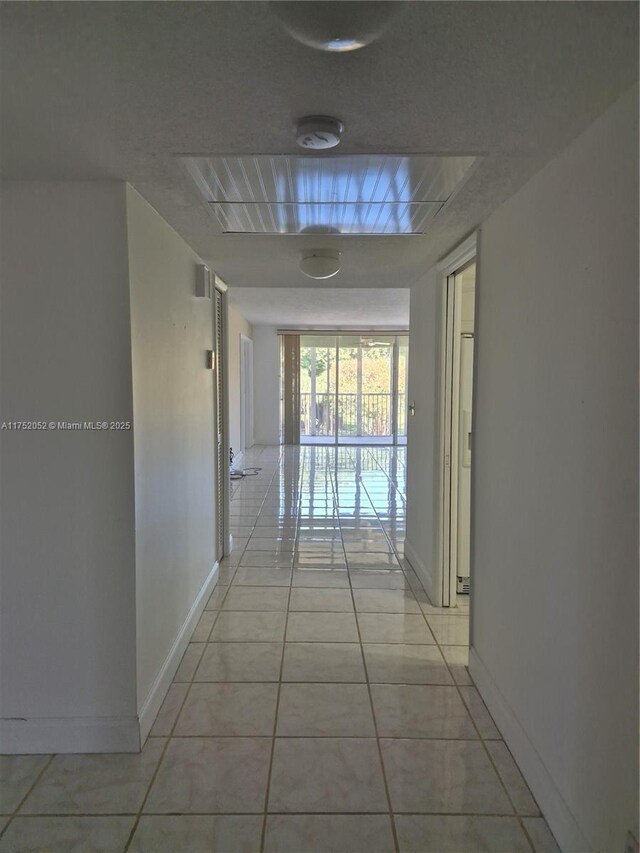 2650 S Course Dr Unit 410, Pompano Beach, FL 33069 - hallway with light tile patterned floors and baseboards