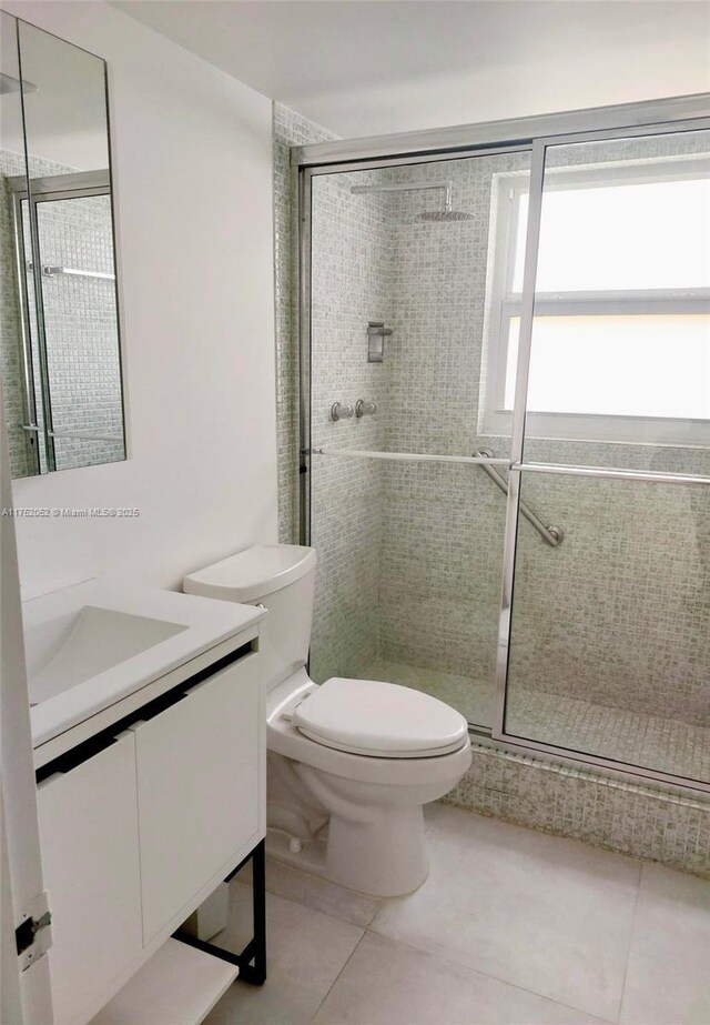 2650 S Course Dr Unit 410, Pompano Beach, FL 33069 - bathroom featuring tile patterned floors, toilet, vanity, and a stall shower