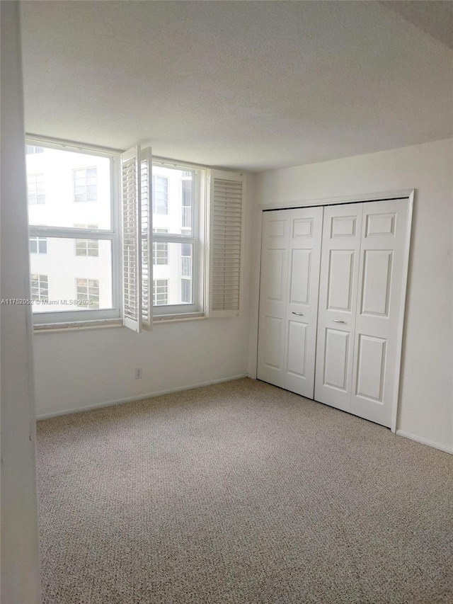 2650 S Course Dr Unit 410, Pompano Beach, FL 33069 - unfurnished bedroom with carpet flooring, baseboards, and a closet