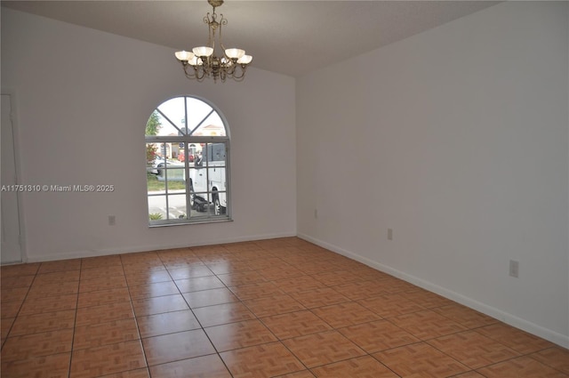 spare room featuring baseboards, light tile patterned floors, and a notable chandelier