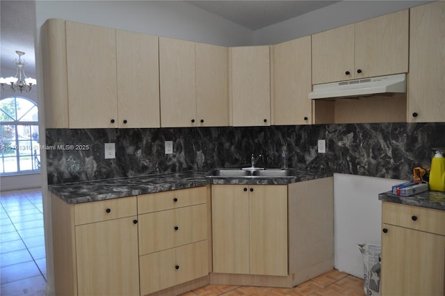 kitchen with light brown cabinets, a sink, and under cabinet range hood