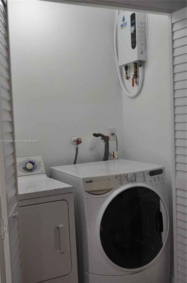 washroom with laundry area, water heater, and washer and clothes dryer