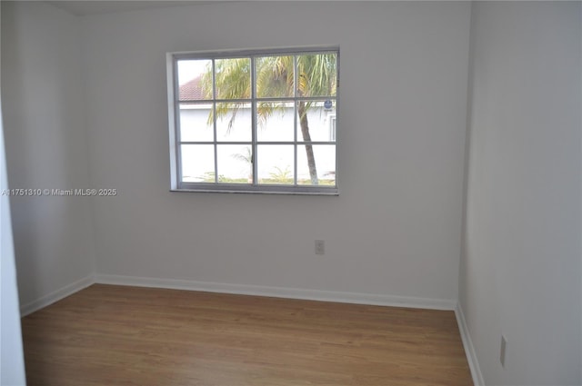 empty room with wood finished floors and baseboards