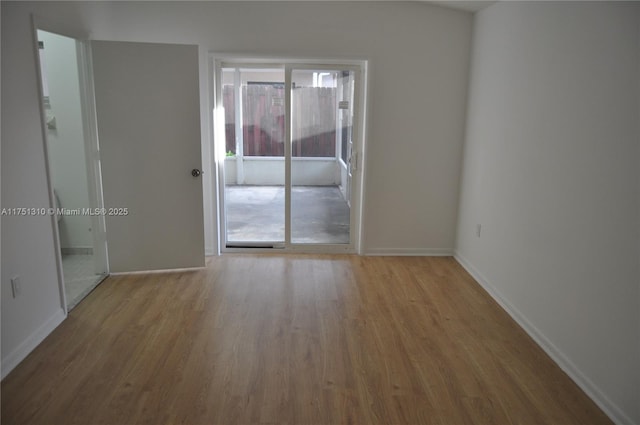 spare room featuring light wood-style floors and baseboards