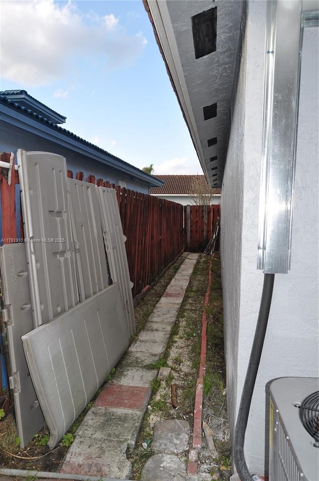 view of side of property featuring fence and stucco siding