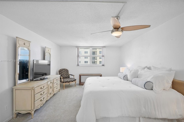 bedroom featuring a textured ceiling, ceiling fan, baseboards, and light colored carpet