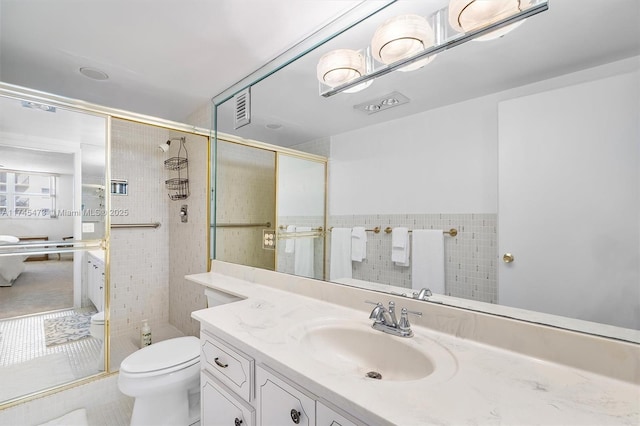 full bath with visible vents, toilet, a stall shower, and vanity