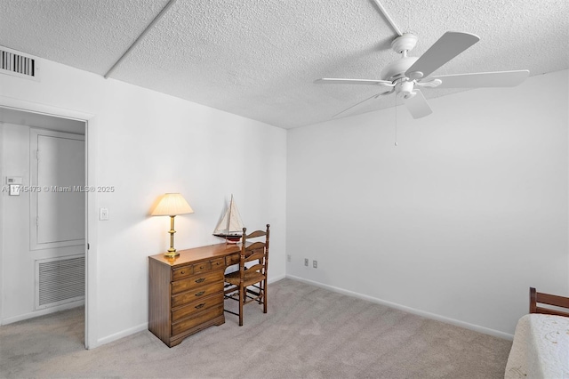 home office with light carpet, visible vents, and a textured ceiling