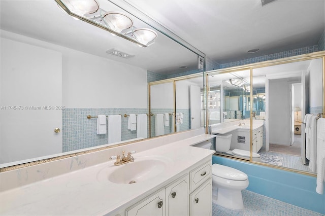 full bathroom with tile patterned flooring, shower / bath combination with glass door, vanity, and toilet