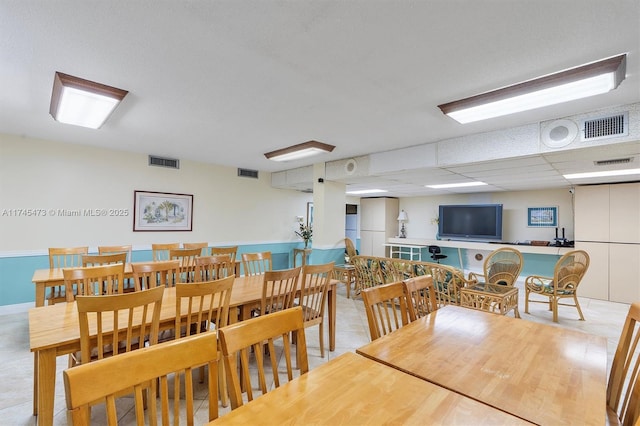 dining space with a drop ceiling and visible vents