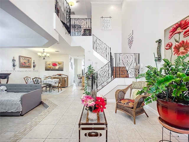 living room featuring a chandelier, light tile patterned floors, a towering ceiling, and stairs