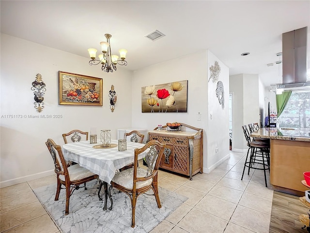 dining room featuring baseboards, light tile patterned flooring, visible vents, and a notable chandelier