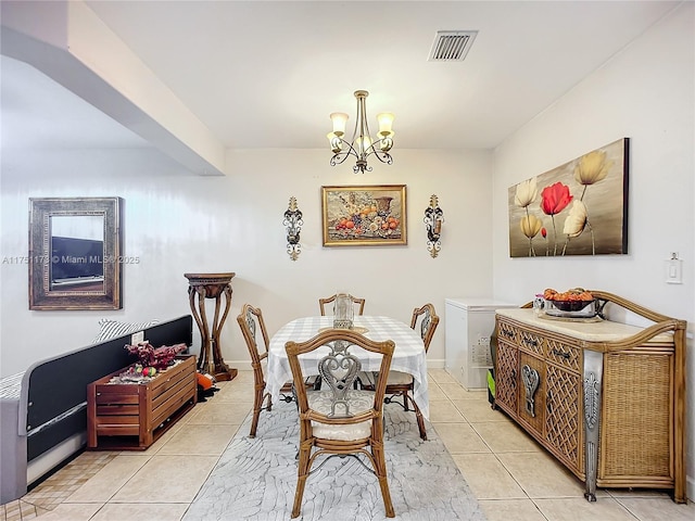 dining space featuring baseboards, light tile patterned flooring, visible vents, and an inviting chandelier