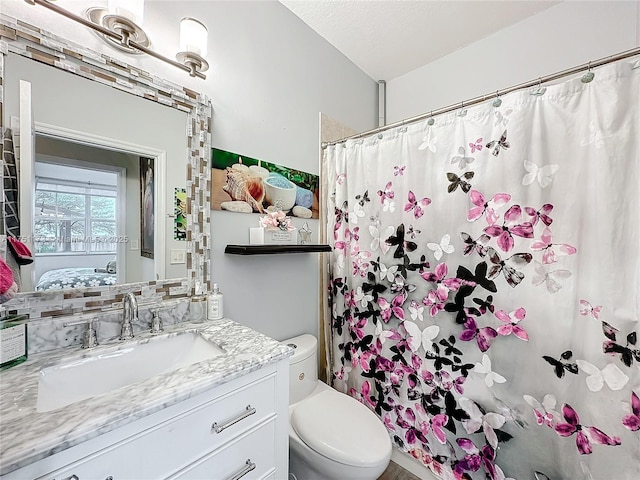 bathroom with lofted ceiling, toilet, ensuite bathroom, a textured ceiling, and vanity