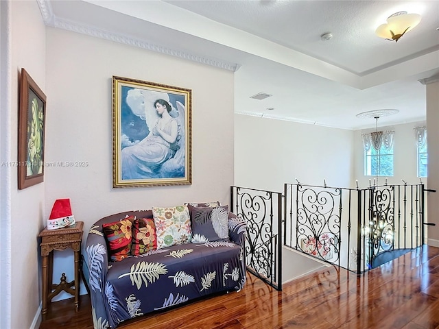 sitting room featuring visible vents, an upstairs landing, wood finished floors, a chandelier, and baseboards