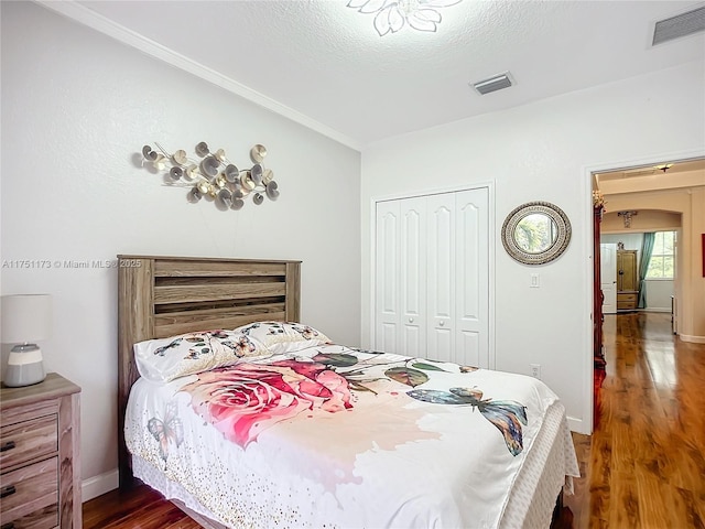 bedroom featuring baseboards, a closet, visible vents, and dark wood-style flooring