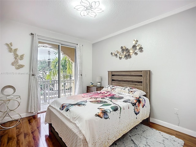 bedroom featuring a textured ceiling, dark wood-style flooring, baseboards, access to exterior, and crown molding