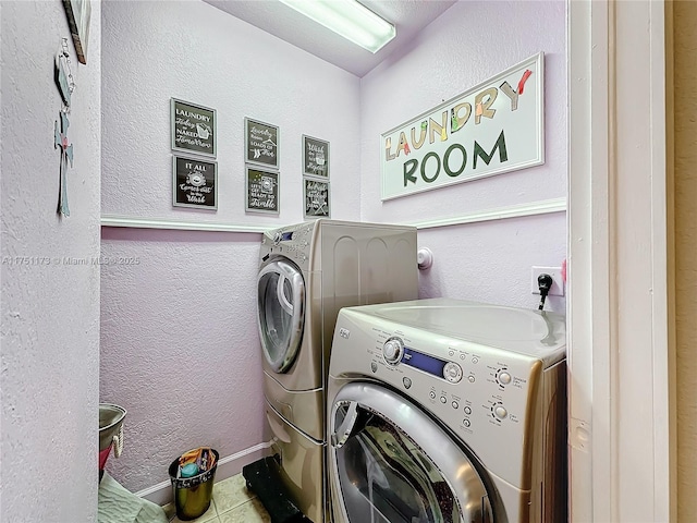 laundry room with a textured wall, laundry area, and separate washer and dryer