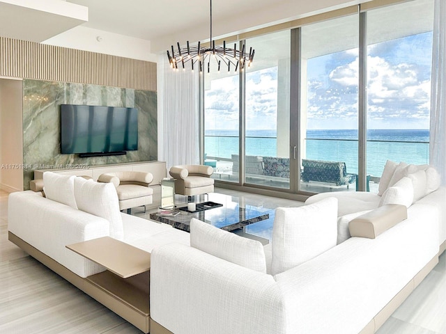 living area with a chandelier, expansive windows, and a water view