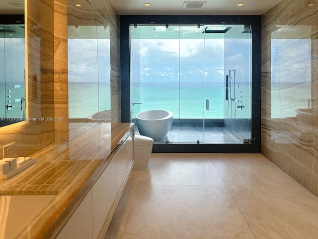 full bathroom with a shower stall, vanity, a soaking tub, and recessed lighting