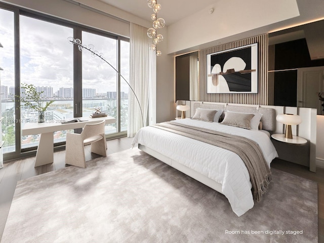 bedroom with access to exterior, multiple windows, and a city view