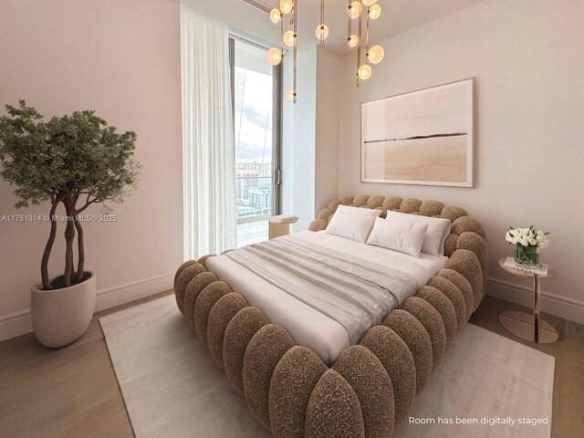bedroom with wood finished floors, baseboards, and access to outside