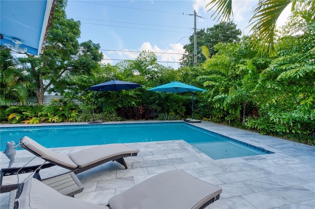 outdoor pool with a patio and fence