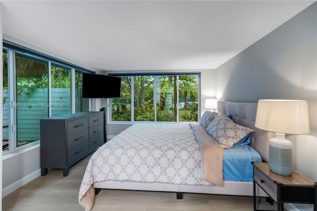 bedroom with light wood-style floors and baseboards