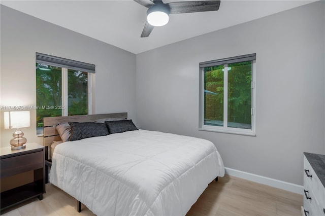 bedroom featuring light wood-style floors, ceiling fan, and baseboards