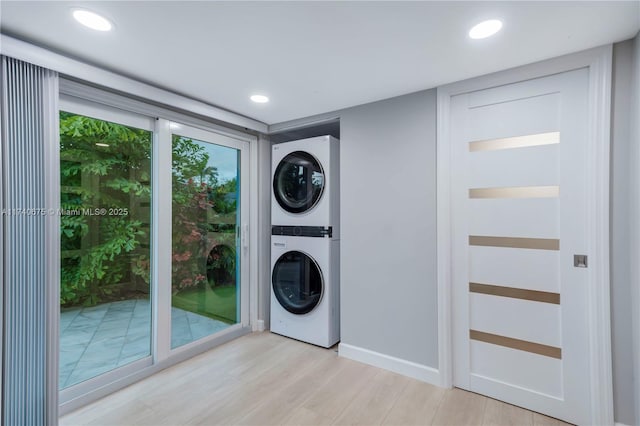 washroom with stacked washer and dryer, light wood-type flooring, laundry area, and recessed lighting