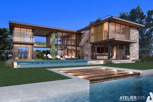 rear view of house featuring stone siding, an outdoor pool, a patio area, and a yard