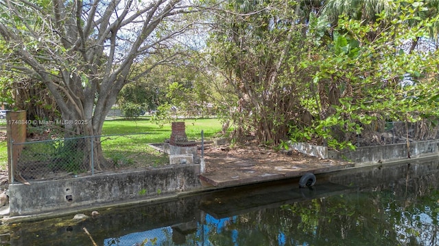 exterior space with a water view and fence