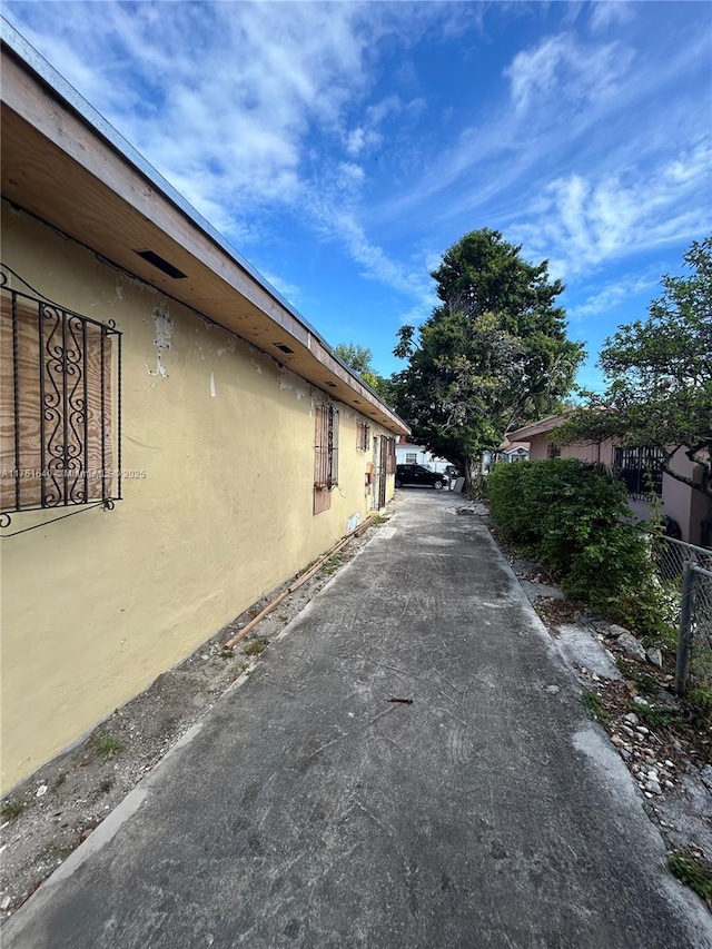 view of property exterior featuring fence and stucco siding