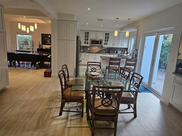 dining area with light wood-style floors and recessed lighting