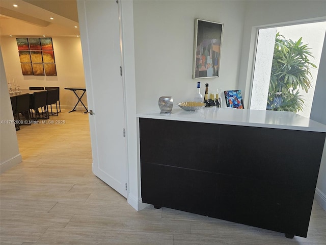 interior space with baseboards, a dry bar, recessed lighting, and light wood-style floors