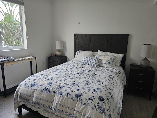 bedroom with multiple windows and wood finished floors