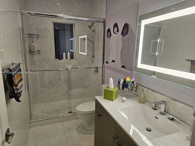 bathroom featuring a shower stall, vanity, and toilet