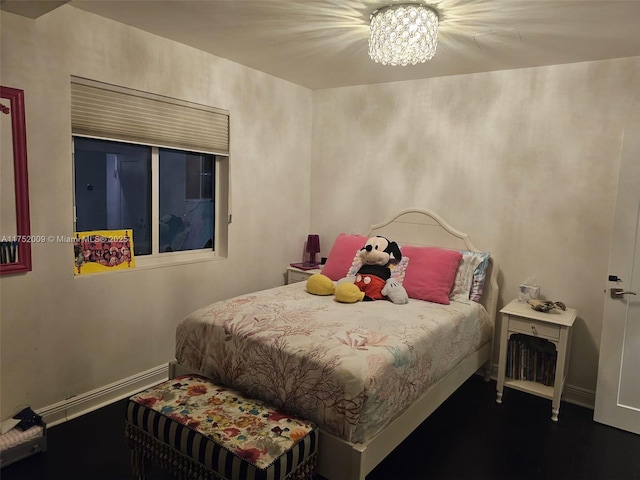 bedroom with a baseboard heating unit, a chandelier, and baseboards